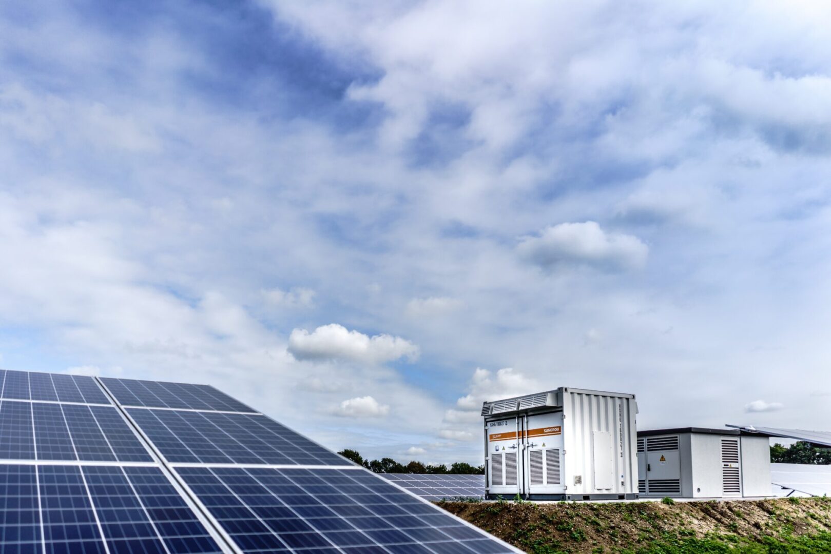 A large solar panel sitting on top of a green field.